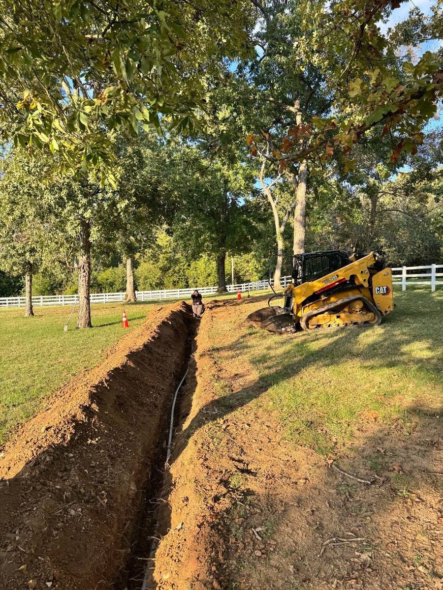 Waterline trenching and PEX install for a new garden in LaVergne, TN using our Cat 265 Compact Track Loader with Trenching attachment.