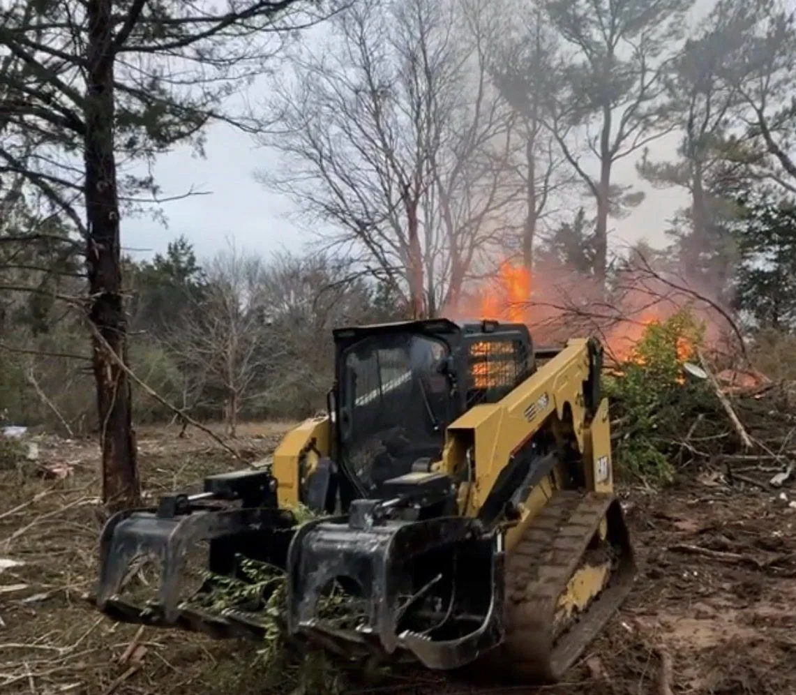 Lot clearing in progress — our CAT 265 with grapple rake stacking brush for a controlled burn on a Spring Hill, TN property